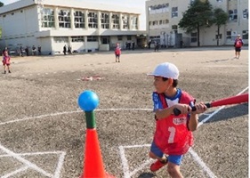 バッターボックスでバットを構えている児童の写真