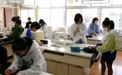 ミシン作業の補助をする学習ボランティアの写真