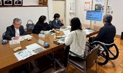 着席している委員たちとコースについて説明する職員たちの写真