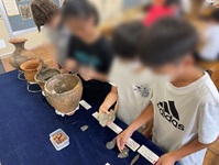本物の土器に触る児童たちの写真