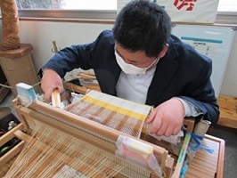 機織りの実演をする生徒の画像