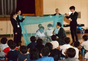 小学生が蚊帳を体験している写真