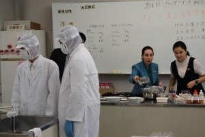 大使が生徒に料理の指導をしている写真