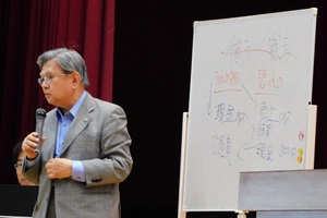 神津信一氏が登壇し、簿記の基礎や税制について説明する様子