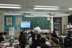 環境化学部の生徒が黒板の前に立ち、茂原市立萩原小学校の児童に授業のテーマや内容を説明している写真
