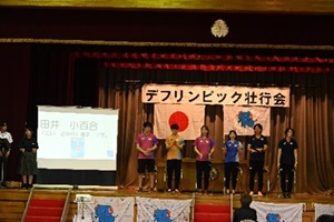 デフ卓球日本代表・ デフ陸上日本代表選手の6名が壇上に横一列で並んでいる写真