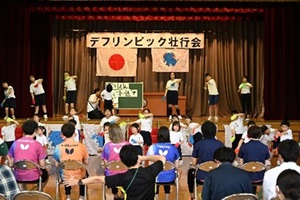 小学部児童が舞台上で応援発表のダンス「しゅわしゅわデフリンピック」を踊っている写真