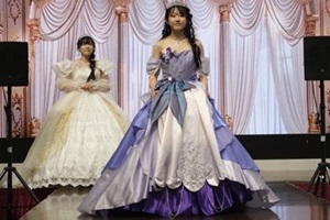 紫とピンクのドレスを着てステージに立つ生徒の写真