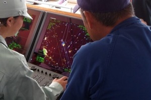 レーダーをのぞき込む生徒と指導者の写真
