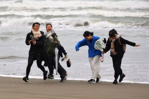 波打ち際ではしゃぐ生徒たちの写真