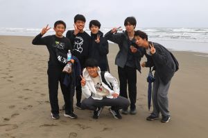 海岸で記念撮影をする生徒たちの写真