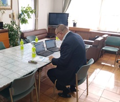 パソコンの前で中学生に説明を行う企業担当者の写真