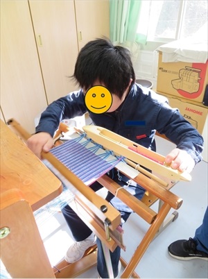 生徒が作品の生地を織っている様子