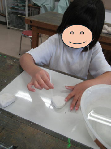 生徒が紙粘土に模様をつけている様子