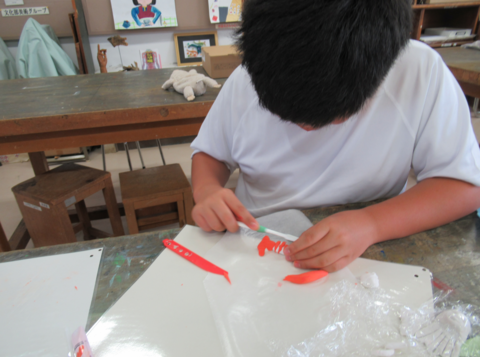 生徒が紙粘土で寿司を作っている様子