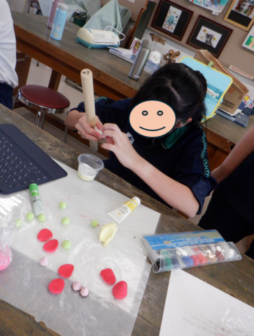 生徒が紙粘土の形を整えている様子