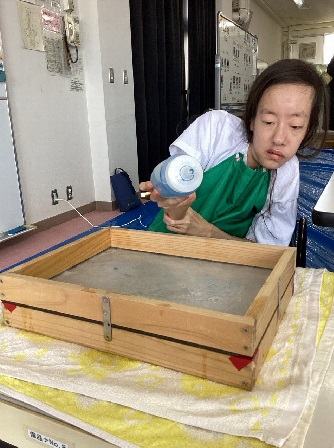 生徒が漉いた紙にインクを垂らしている様子