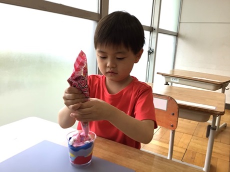 小学部男子児童が紙粘土を絞っているところ