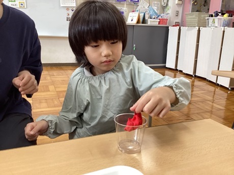 男子児童が赤い粘土を使って製作しているところ