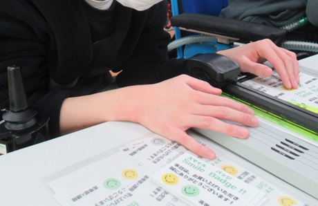 生徒が作品の説明カードを切っている様子