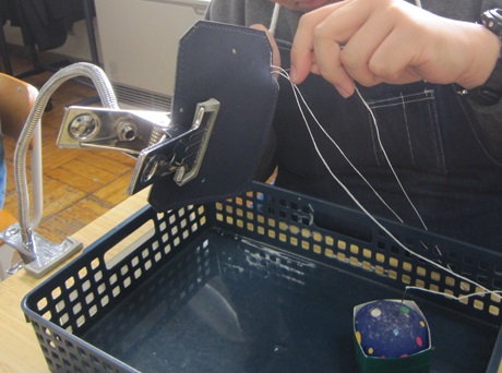 生徒が革の作品を縫っている様子