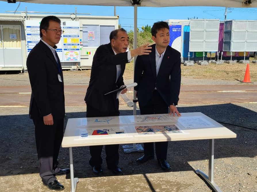 南白亀排水機場における現地視察の際、資料を見ながら町長の説明を聞く知事の画像
