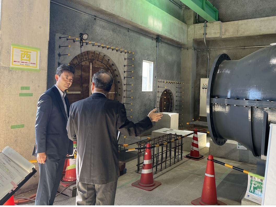 南白亀排水機場における現地視察の際、設備を見ながら町長の説明を聞く知事の画像