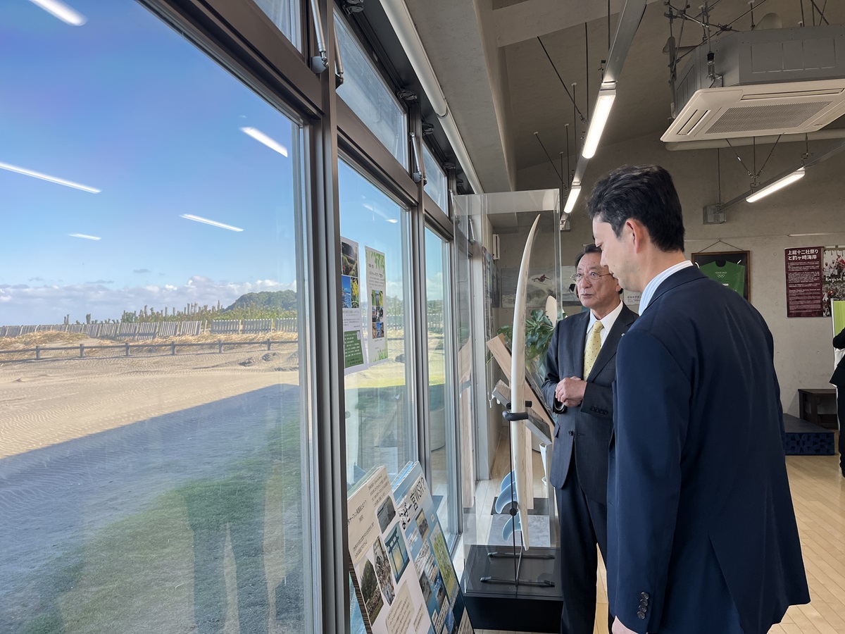釣ヶ崎海岸広場における現地視察の際、展示を見ながら町長の説明を聞く知事の画像