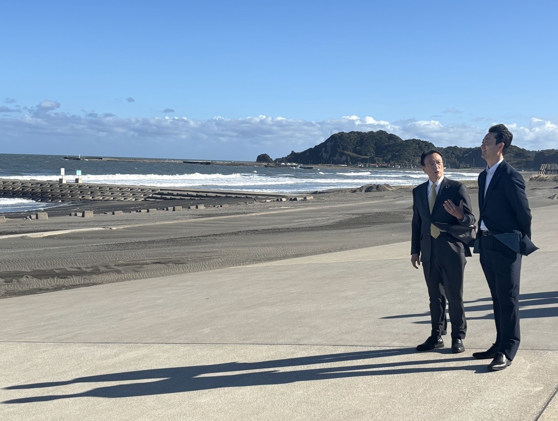 釣ヶ崎海岸広場における現地視察の際、海岸で町長の説明を聞く知事の画像