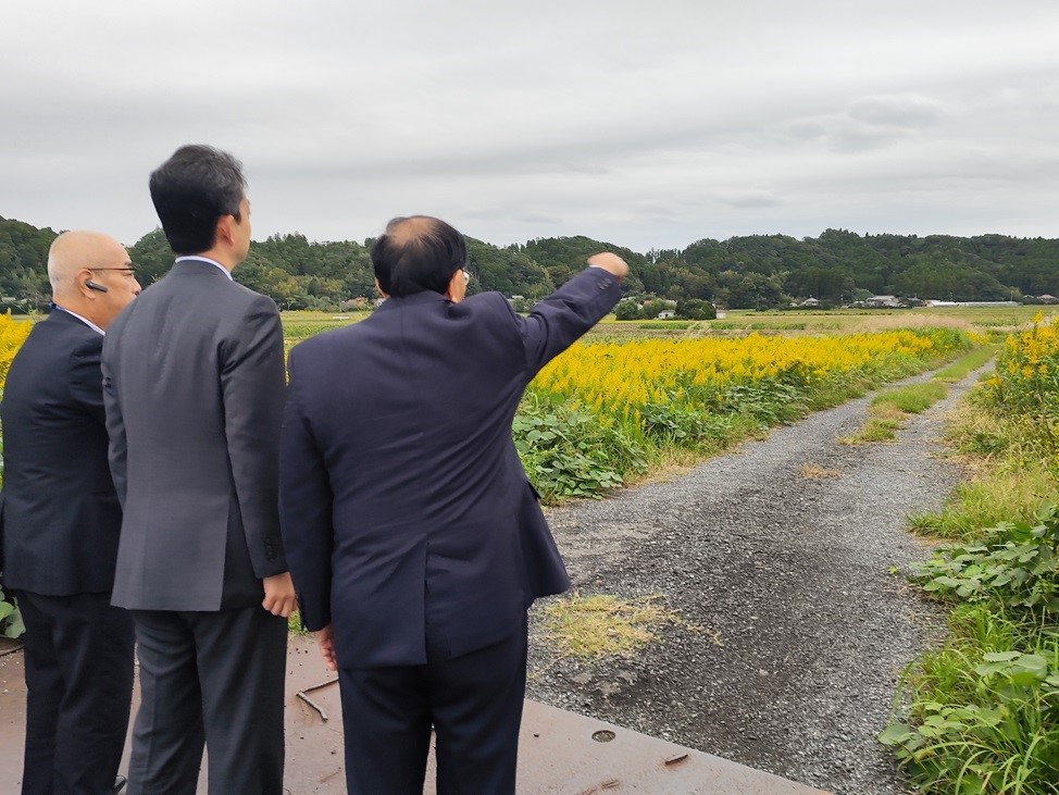 国道465号苅谷新田野バイパス整備予定地周辺における現地視察の際、周辺の状況を見ながら市長の説明を聞く知事の画像